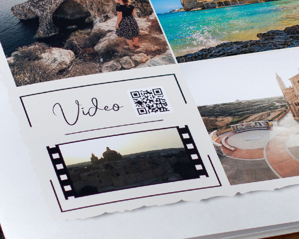 Seite eines CEWE FOTOBUCHs mit Urlaubsfotos und einem QR-Code neben dem Schriftzug "Video".